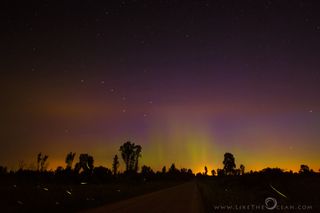 Photographer Sathya shot this image of the northern lights leaving a warm glow in the sky over Harmon, Illinois. The Big Dipper can be seen to the left of the middle, just above the trees. The streaks of light near the ground are fireflies.