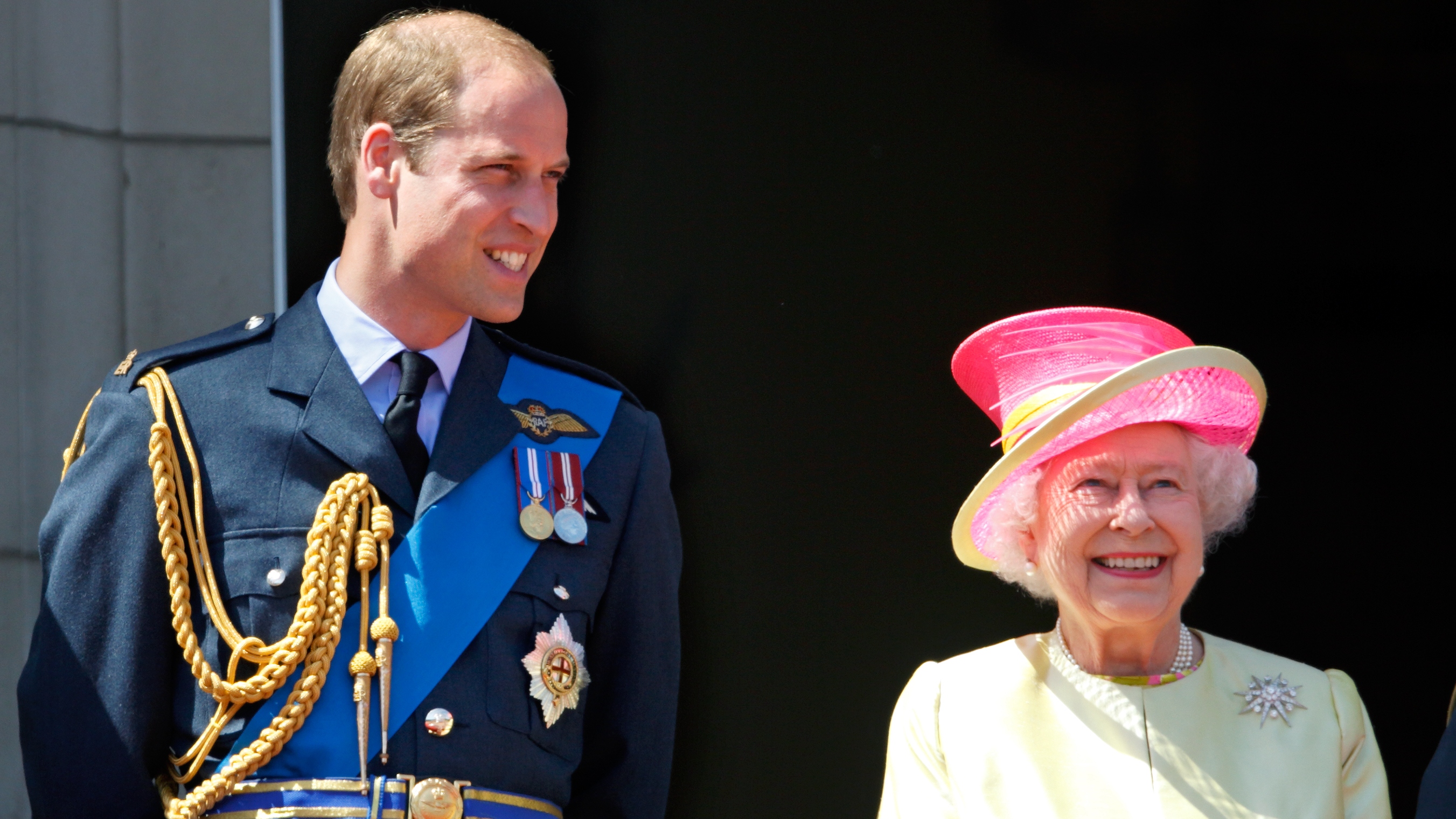 Prince William and Queen Elizabeth II watch a flypast of Spitfire &amp;amp; Hurricane aircraft from the balcony of Buckingham Palace