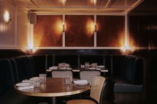 Inside The Palomar London restaurant with velvet booths and round tables