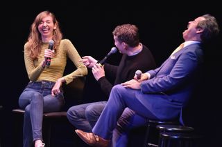 the hosts of comedy bang bang podcast on stage at an event laughing