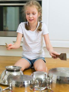 Young girl using kitchen items as drums