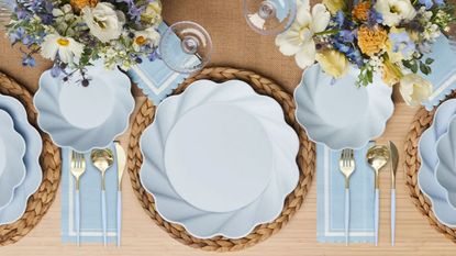 Table set with light blue bamboo plates, cutlery, rattan mats and flowers