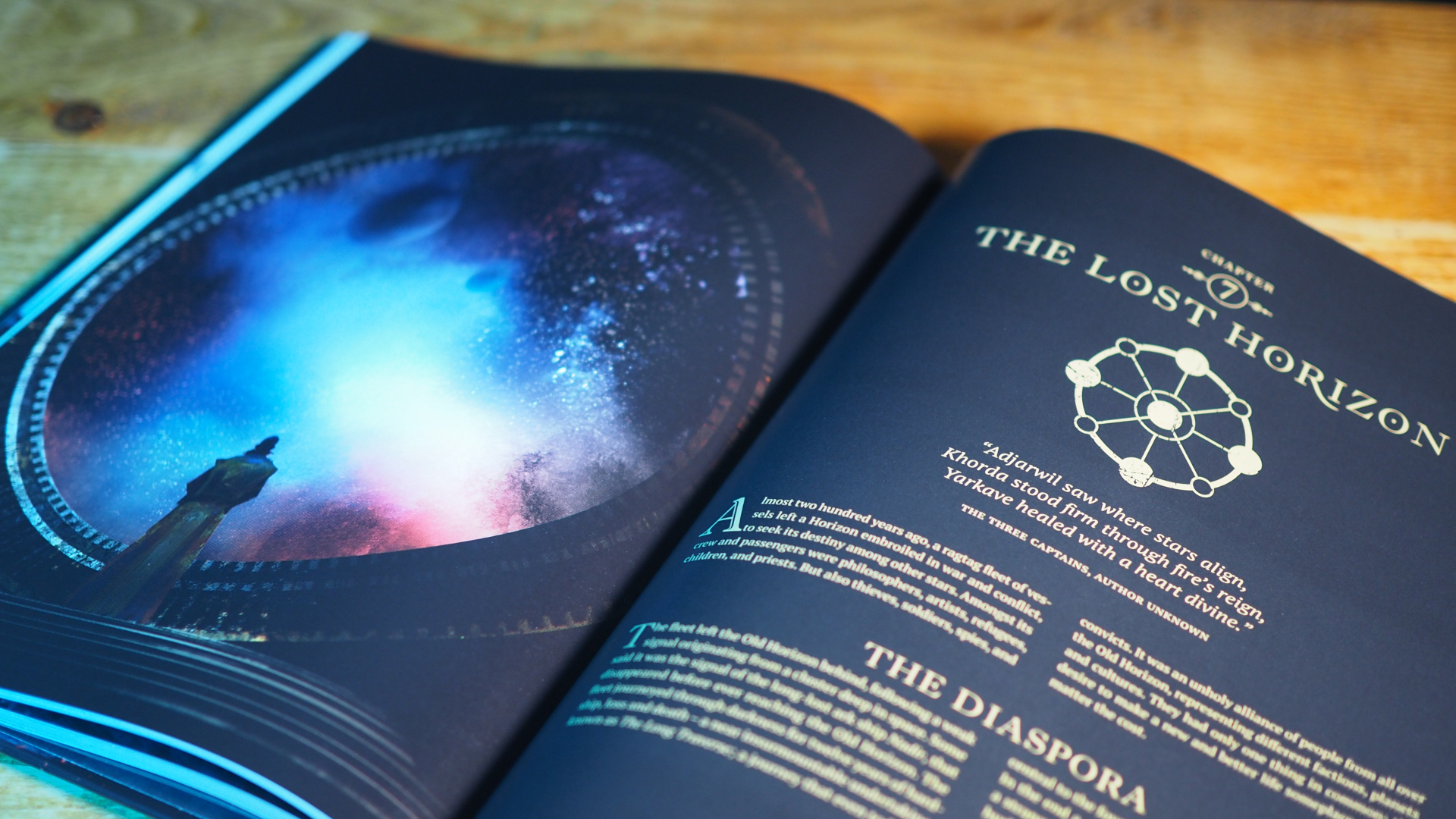 Coriolis: The Great Dark rulebook on a wooden table, open on an image of someone looking at the cosmos, with &#039;The Lost Horizon&#039; chapter beside it