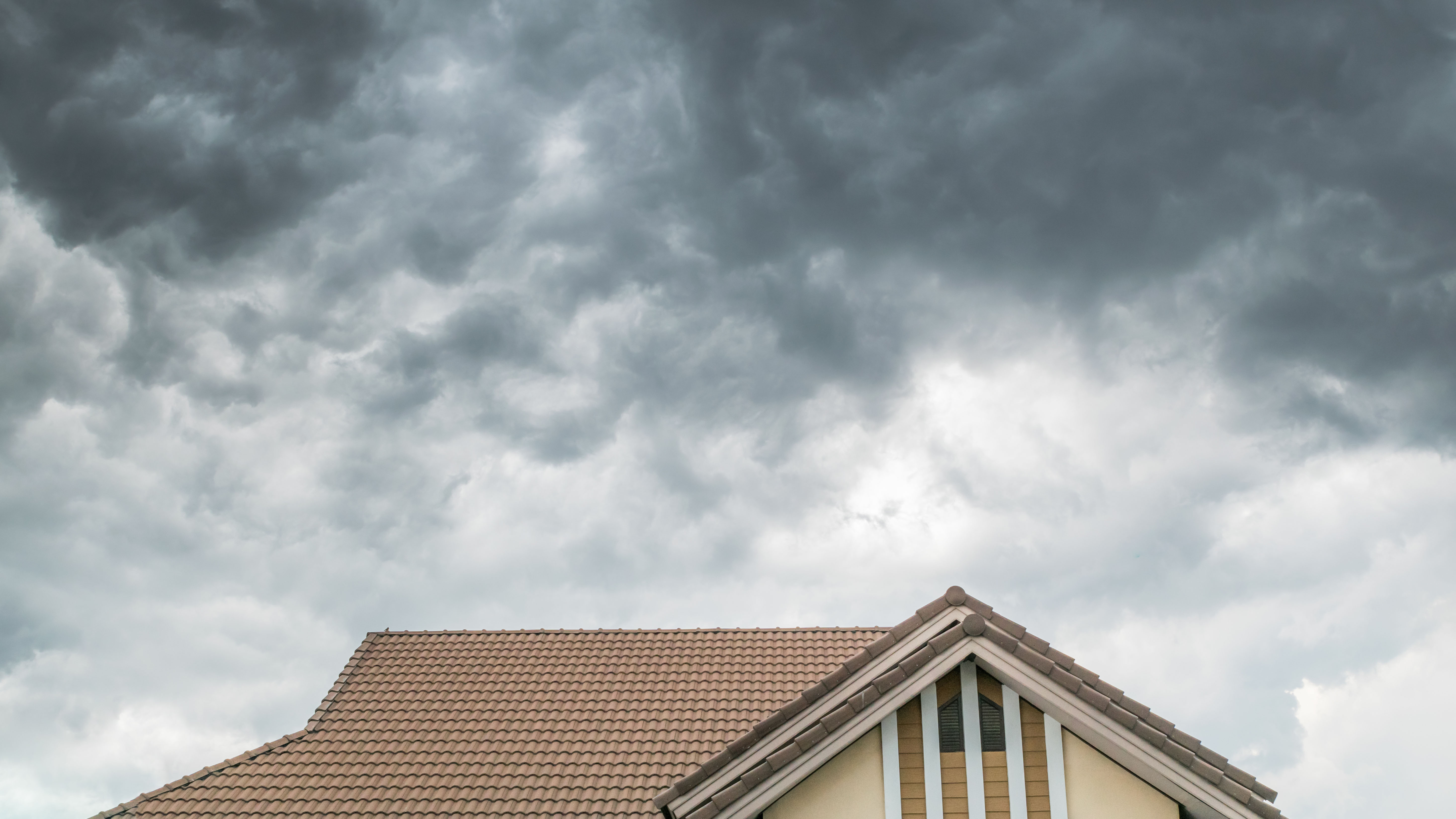 Dark clouds building up over the roof of a house