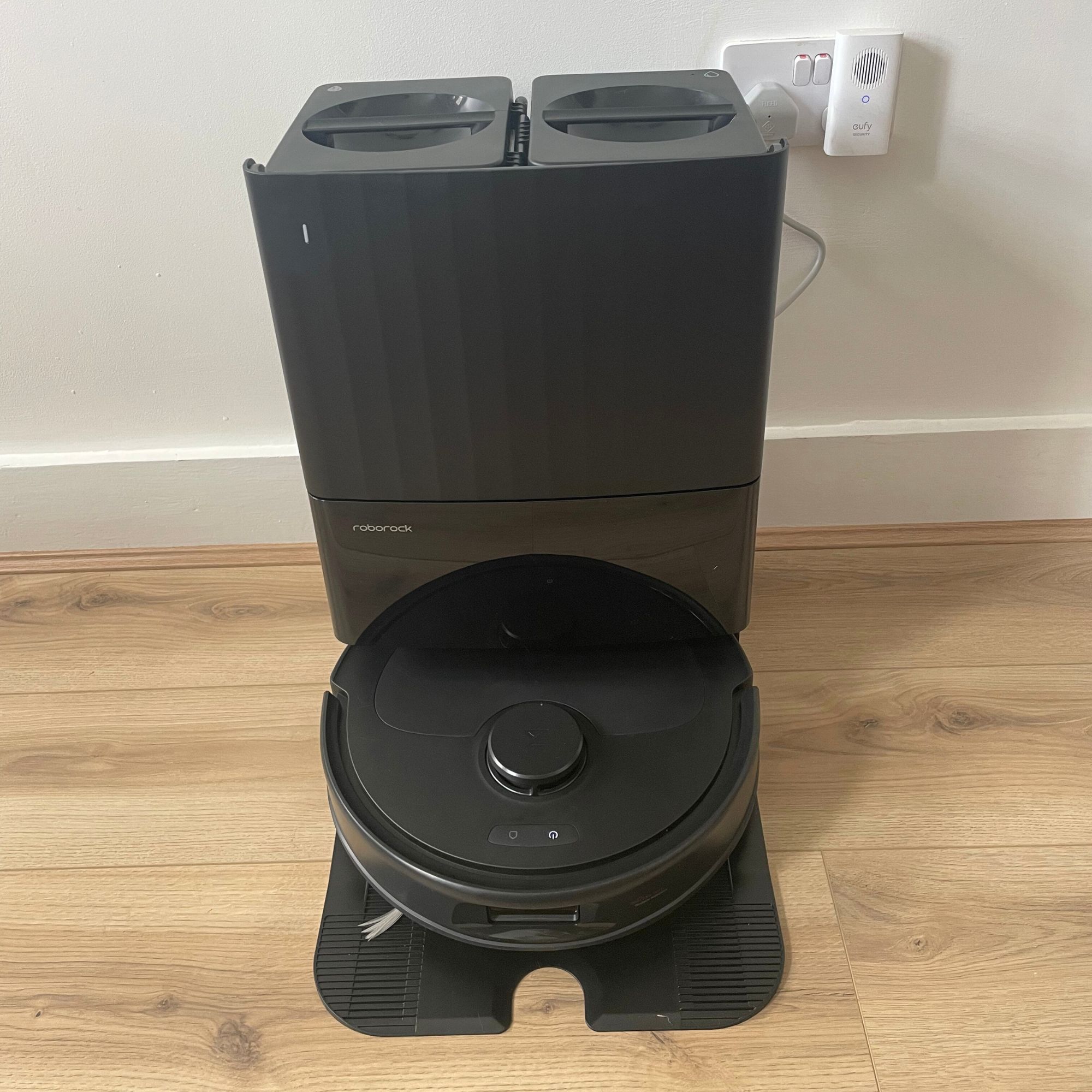 Roborock QV 35S Robot Vacuum With Mop in docking station on wood-effect flooring