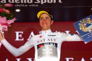 Team Vismaâ€“Lease a Bike's Belgian rider Cian Uijtdebroeks celebrates his best young rider's white jersey on the podium of the 6th stage of the 107th Giro d'Italia cycling race, 180 km between Torre del lago Puccini in Viareggio and Rapolano Terme, on May 9, 2024 in Rapolano Terme. (Photo by Luca Bettini / AFP)