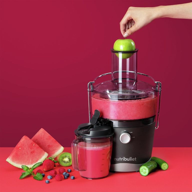 Nutribullet juicer with red juices on a red background. 