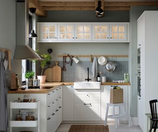 White IKEA kitchen with wooden worktops and gray square tiles