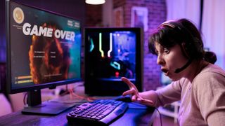 An angry woman wearing a headset and shouting after losing a game on her PC.
