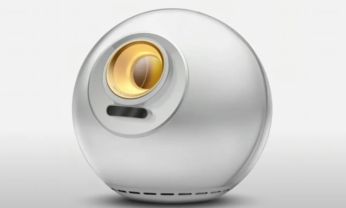 The World Orb, a spherical iris scanner on a grey background. The scanner has a circular area on the front containing a large yellow glass lens.