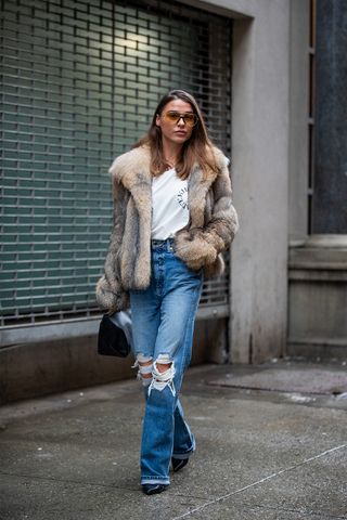 Woman wearing a faux fur jacket outfit.