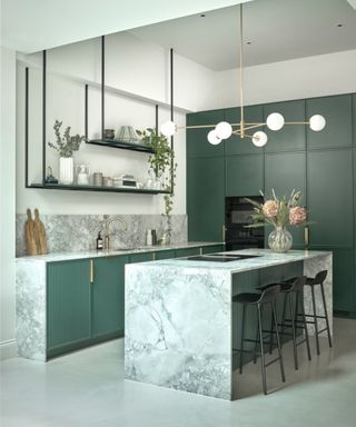 A green and marble kitchen with fluted lower cabinets and micro shaker cabinets on the floor to ceiling storage