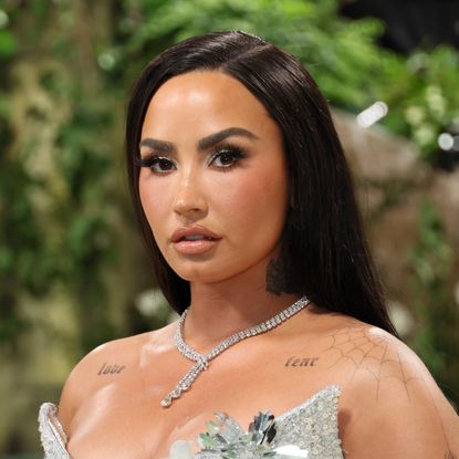 Demi Lovato wears a strapless silver gown and a diamond necklace