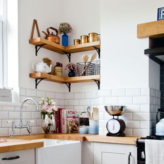 white kitchen corner with open shelving, sink and weighing scales