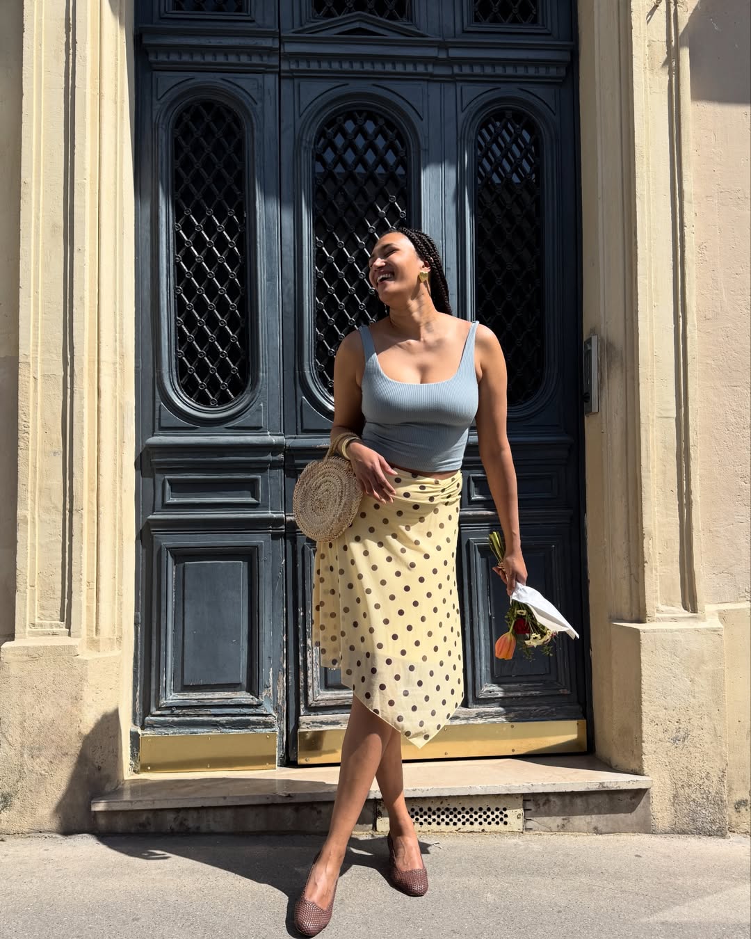 Influencer Lena Farl is wearing a cropped waist top, polkadot skirt and ballet flats.