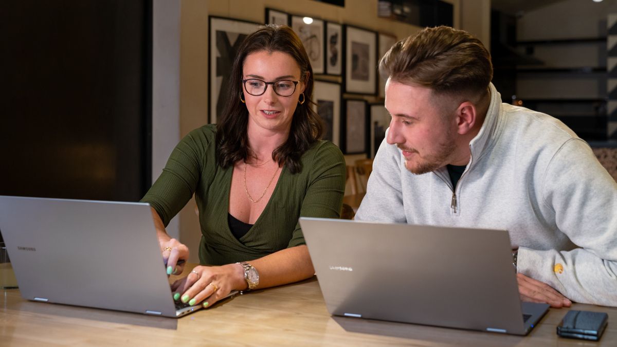 Two people working together, with two Samsung laptops in front of them