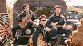 The cast of Backbeat posing with their guitars in Backbeat