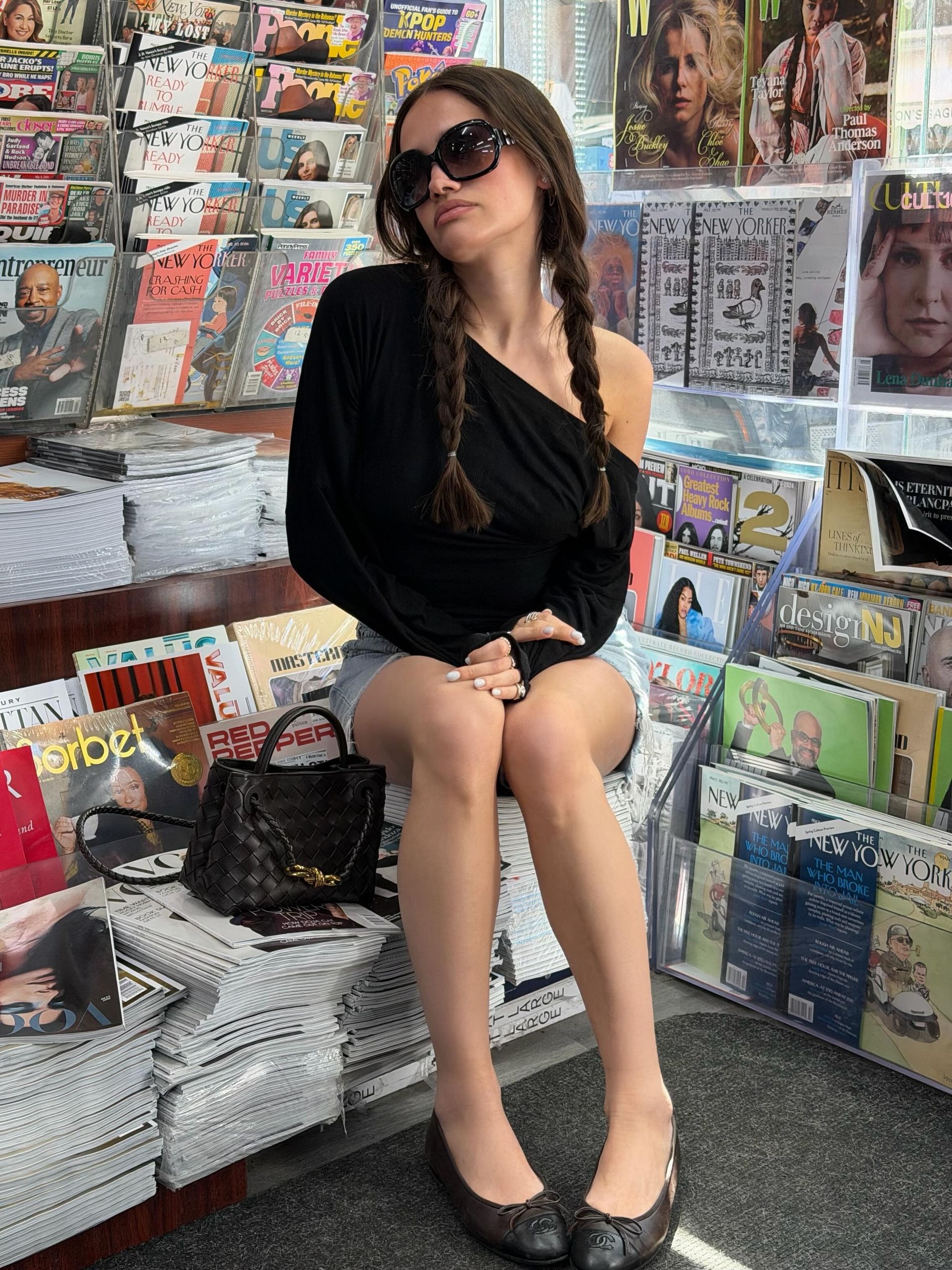Julia wears denim shorts, a black top, and black ballet flats.