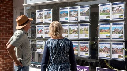 Couple looking in an estate agent's window