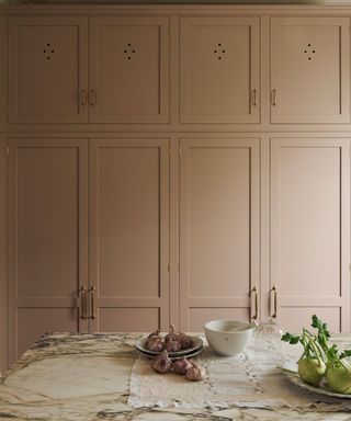 A pink kitchen with marble countertops