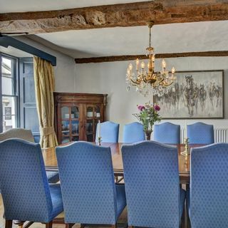 dining room with chandelier with dining table with blue chairs