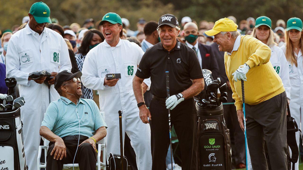 Wayne Elder holds a sleeve of golf balls behind Lee Elder at the 2021 Masters