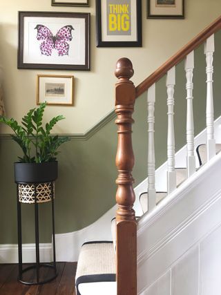 whiet staircase with wooden balustrade and two tone wall