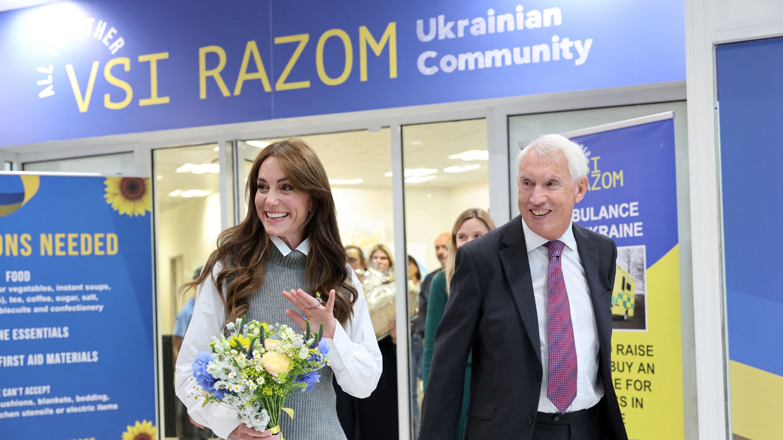 Catherine, Princess of Wales carries a bouquet of flowers as she leaves after visiting the Vsi Razom Community Hub