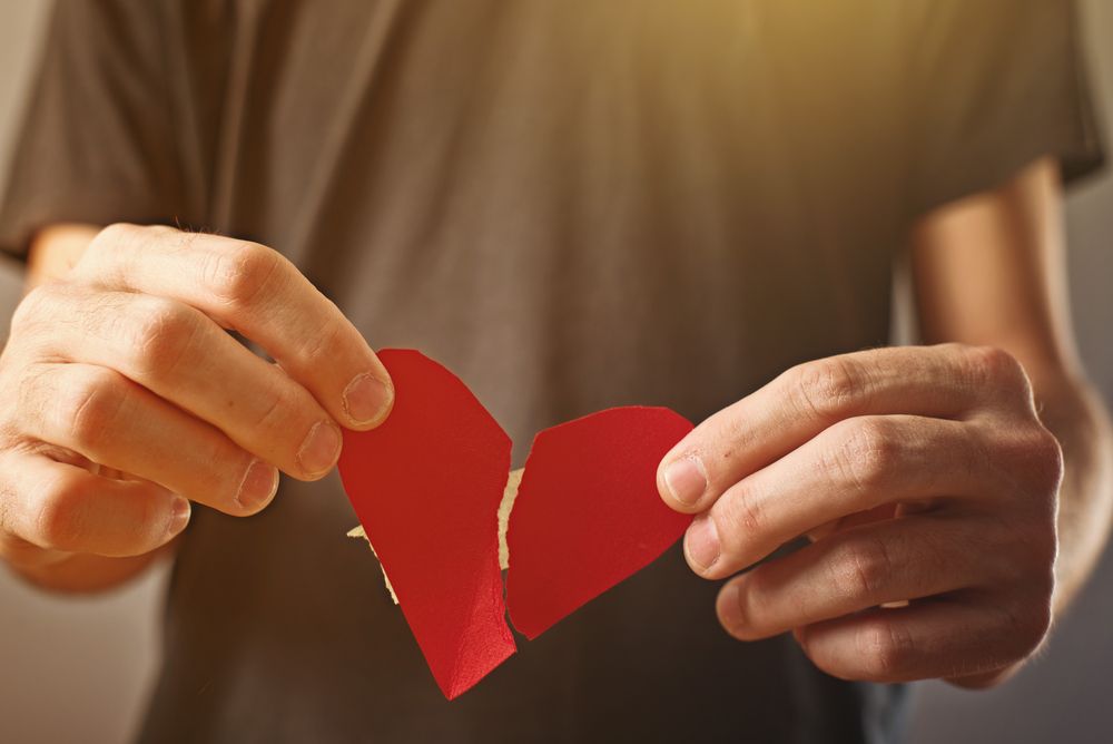 Man holding a paper heart