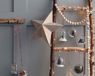 Handmade wooden ladder with glass-effect baubles and fairy lights wrapped around it