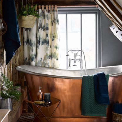 bathroom with copper bathtub and potted plants