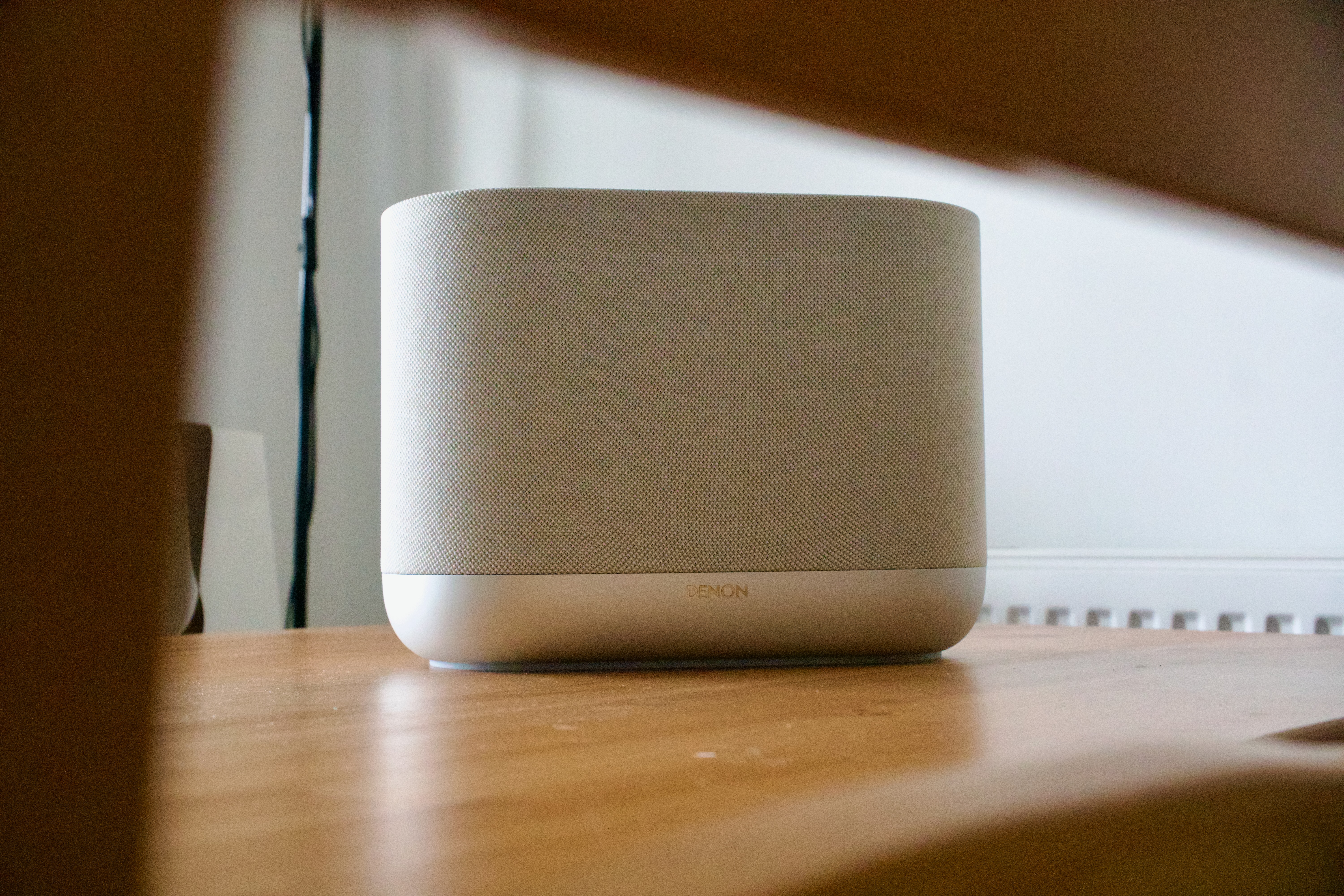 Denon Home 400 home speaker on a wooden surface