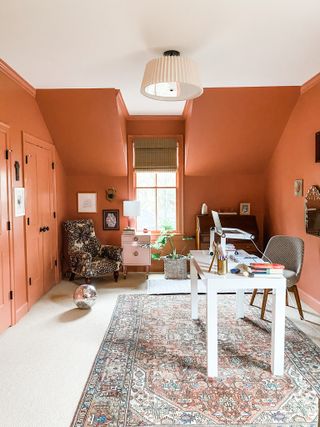 Orange home office with textured rug and armchair