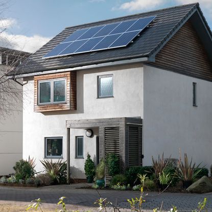 white wall house roof with solar panel and glass window