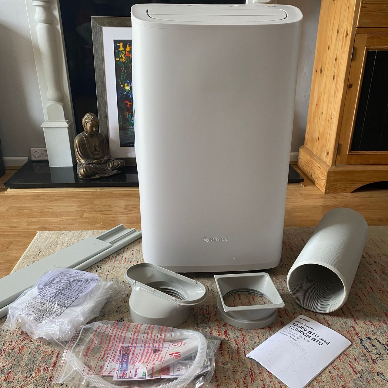 Flat lay of what you get in the box of the Meaco Cirro portable air conditioner, including exhaust hose, window kit and drainage hose