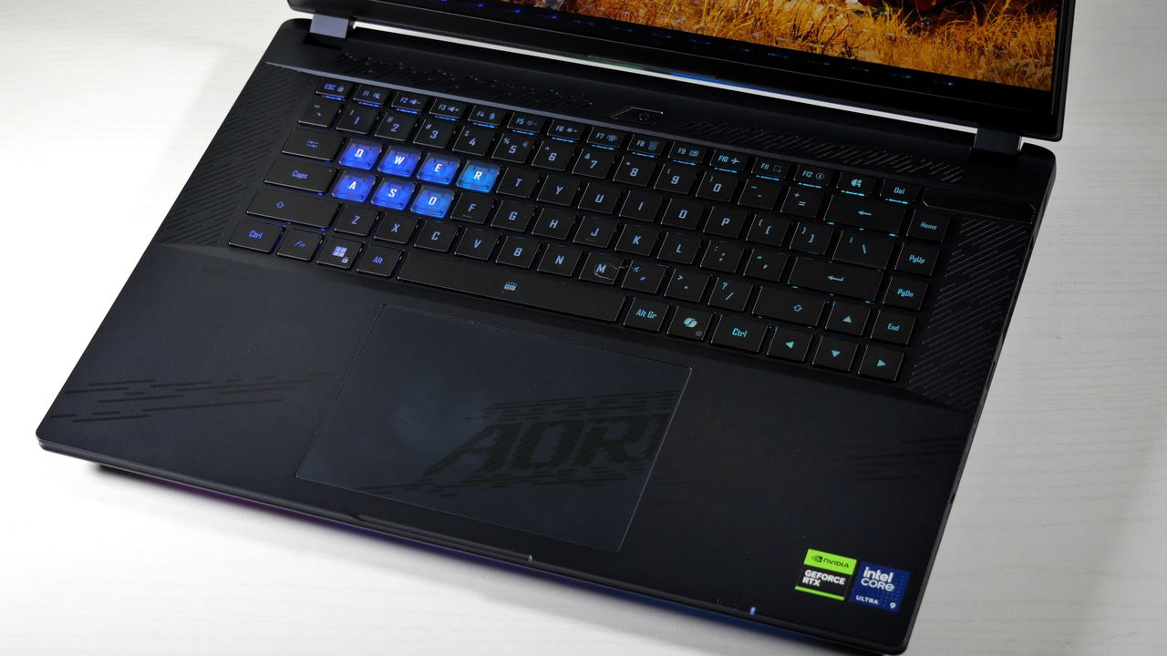 Gigabyte Aorus Master 16 (RTX 5080) opened on a white table, highlighting its RGB-lit keyboard.
