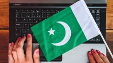 Woman hands and flag of Pakistan on laptop keyboard
