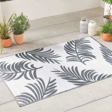 Grey and white palm print rug on outside decking Aldi