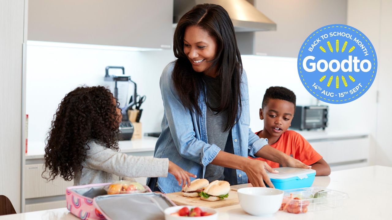 Mum making packed lunches at home with help from her two children