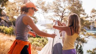 Two women taking down a tent