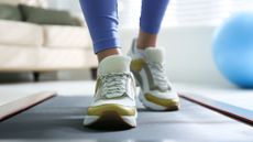 A woman walking on a treadmill in her living room