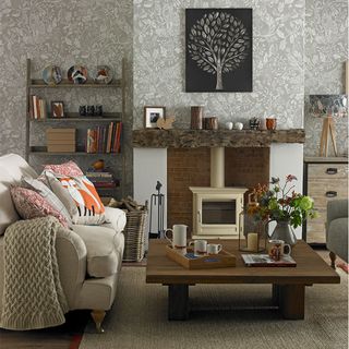 small living room with leafy grey wallpaper stove and log mantel