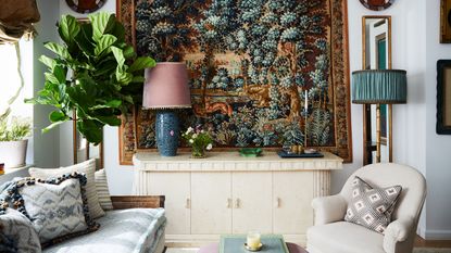 decorative wall hanging behind chunky sideboard and ceramic table lamp