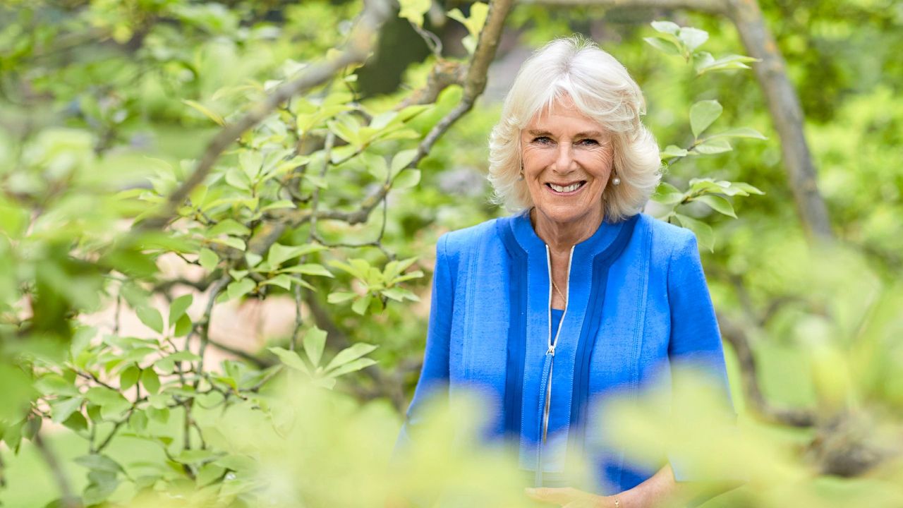 An official portrait of Queen Camilla in a garden 