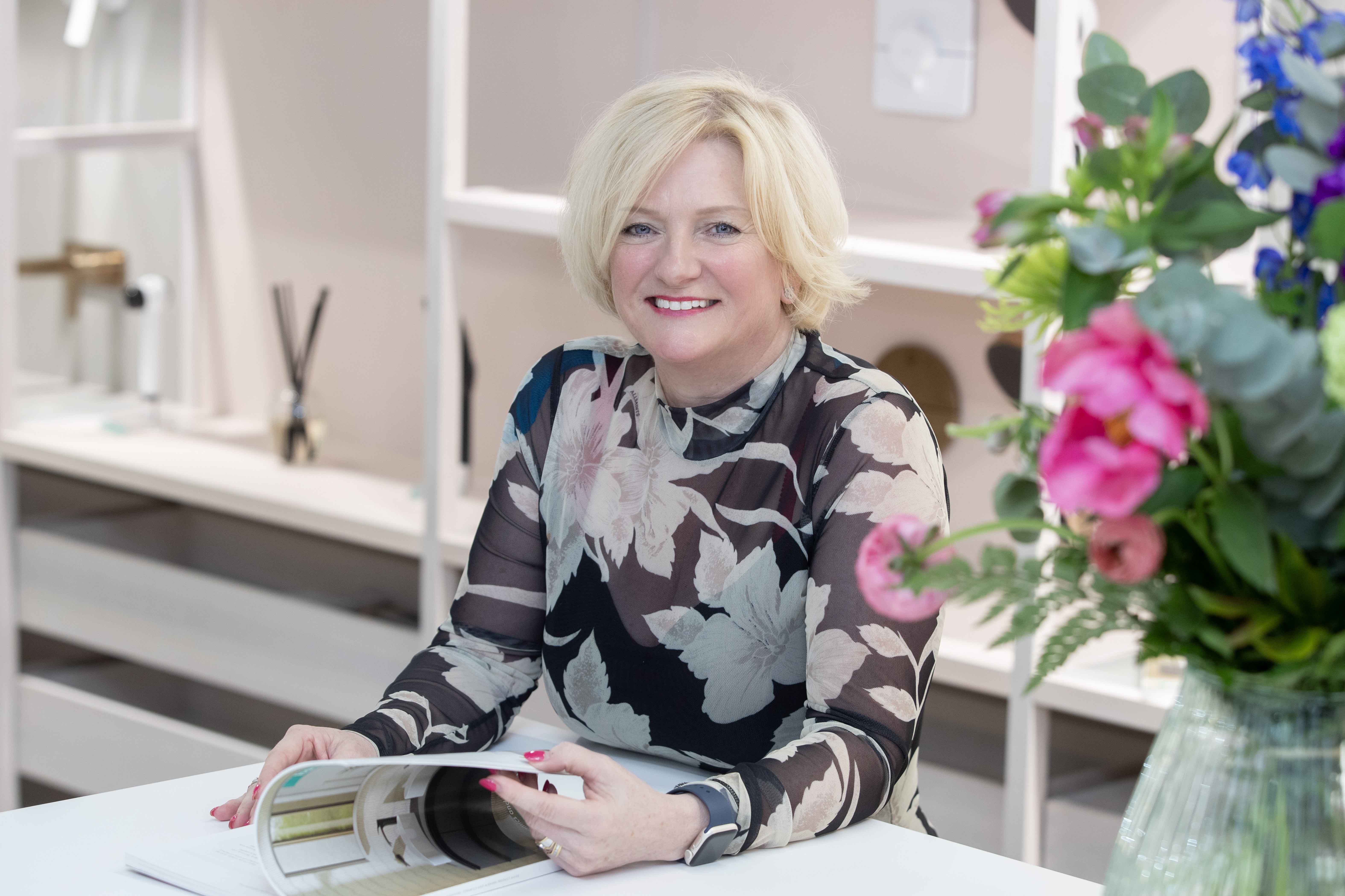 woman smiles to camera with blonde hair