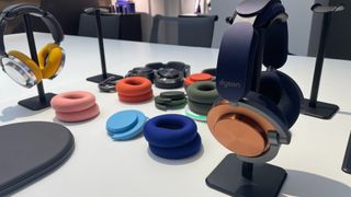 Dyson OnTrac headphones with various finishes and earcup colours laid out on desk