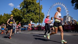 Runners in the London Marathon on the Embankment in Westminster. The Millennium Wheel is in the background