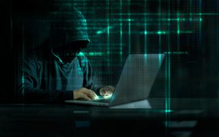 Man hacking laptop with code in background