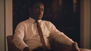 David Oyelowo sitting in a chair with a red tie in Selma