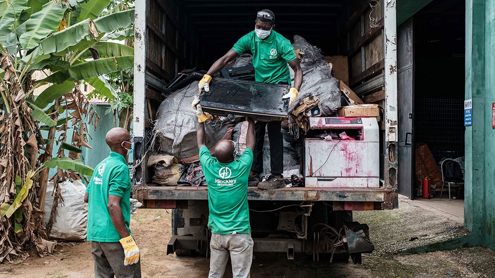 Recycling workers handle monitor waste